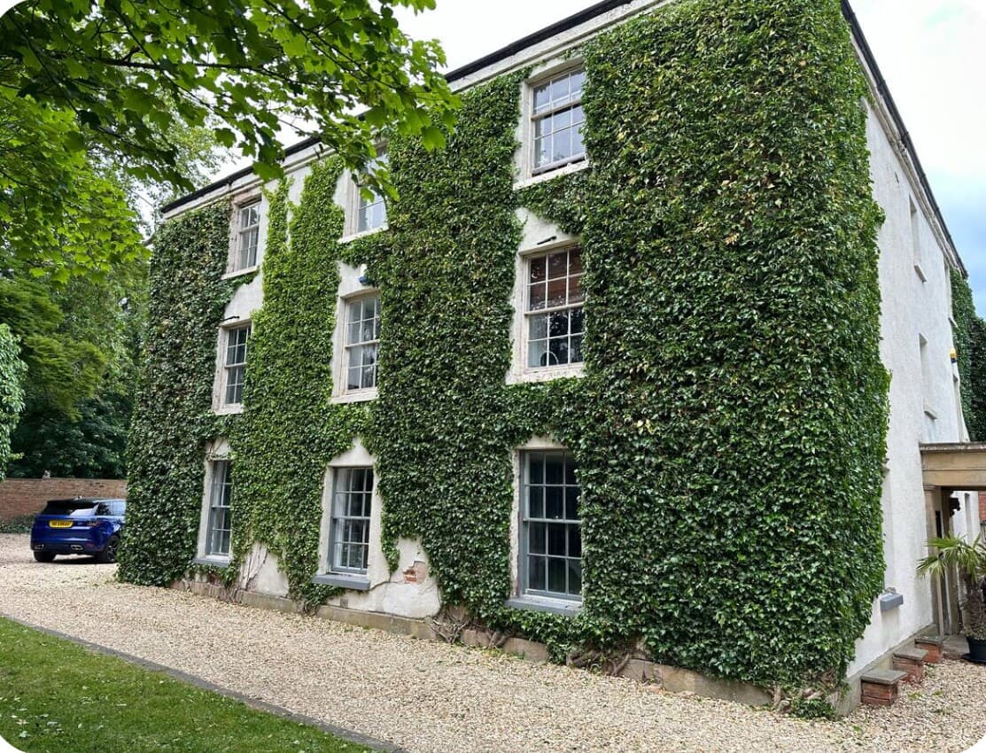 Ivy-clad countryside residence with characterful period windows and gravel approach, nestled in Nottinghamshire parkland